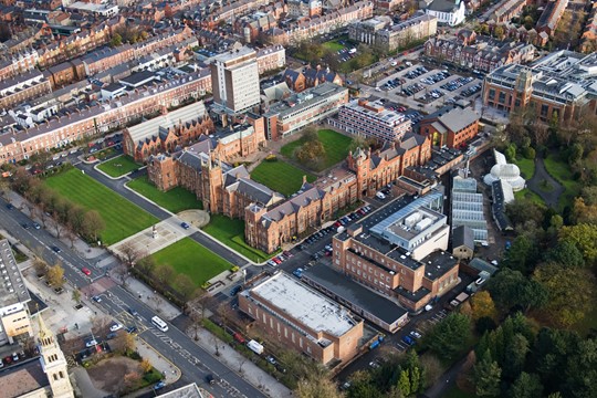 Aerial view of Queen’s University Belfast campus, with lush, green lawns and historic brick buildings in the centre of Northern Ireland’s capital city. 