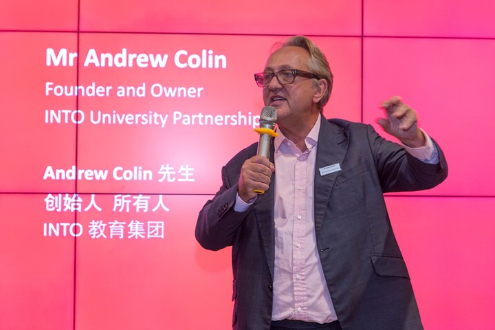 INTO founder and owner Andrew Colin stands in front of pink monitor and speaks to audience in University Access Center in Suzhou, China.