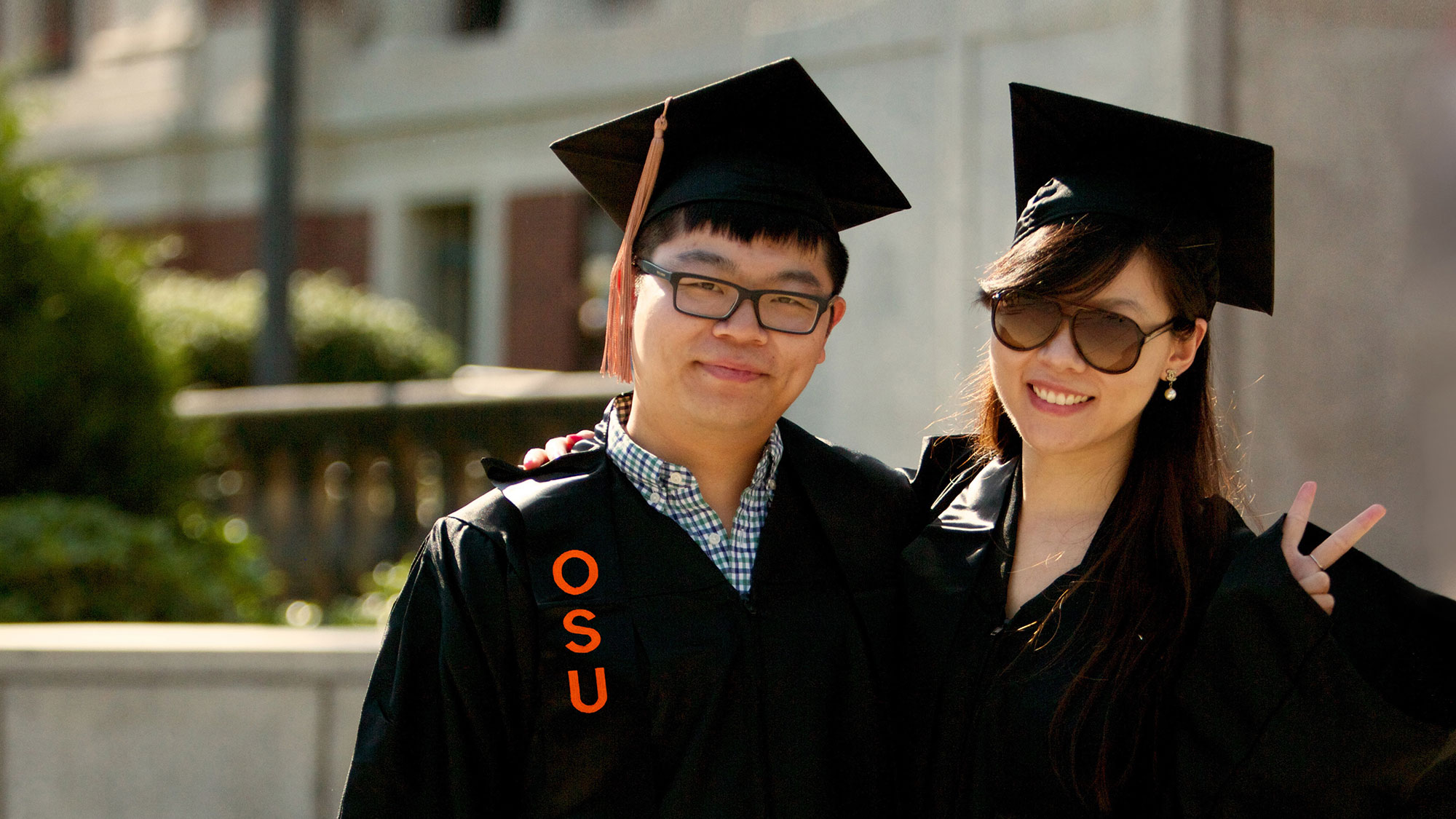 International students at Oregon State University wear cap and gown at graduation ceremony.