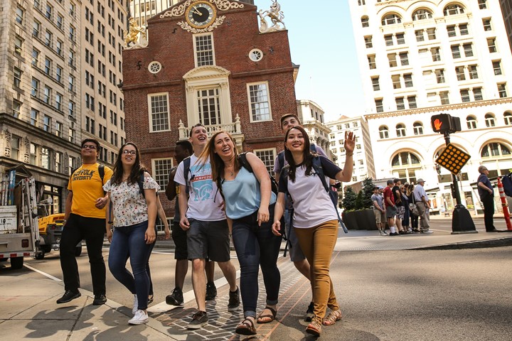 Seven international students from INTO Suffolk University walk through sunny street in downtown Boston.