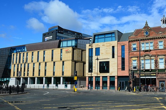 Exterior view of INTO Newcastle University Centre building with tan bricks in heart of Newcastle upon Tyne. 